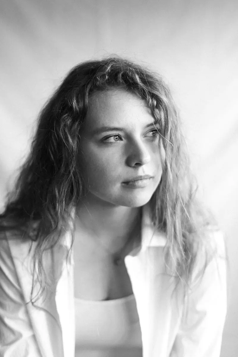 Black and white natural light portrait of a woman with curly hair