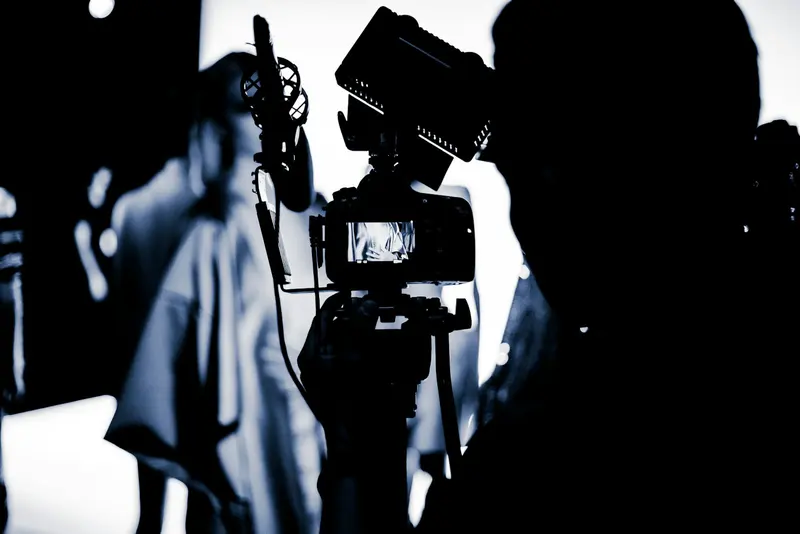 High contrast silhouette of a camera operator with a rigged camera