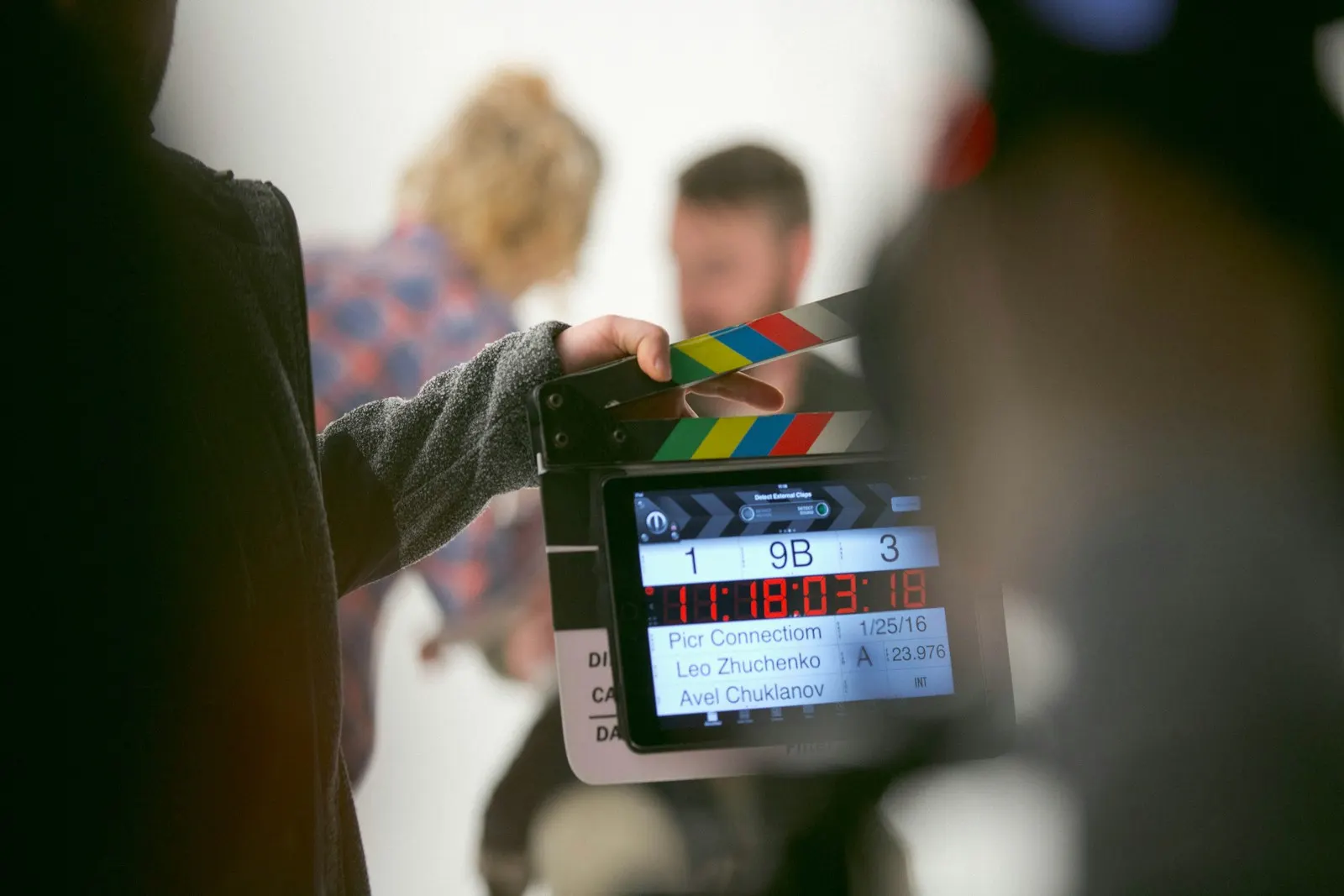 Digital clapperboard held up in front of two actors before a take