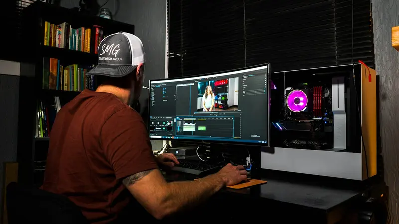 Editor working at a post production desk with a wide monitor