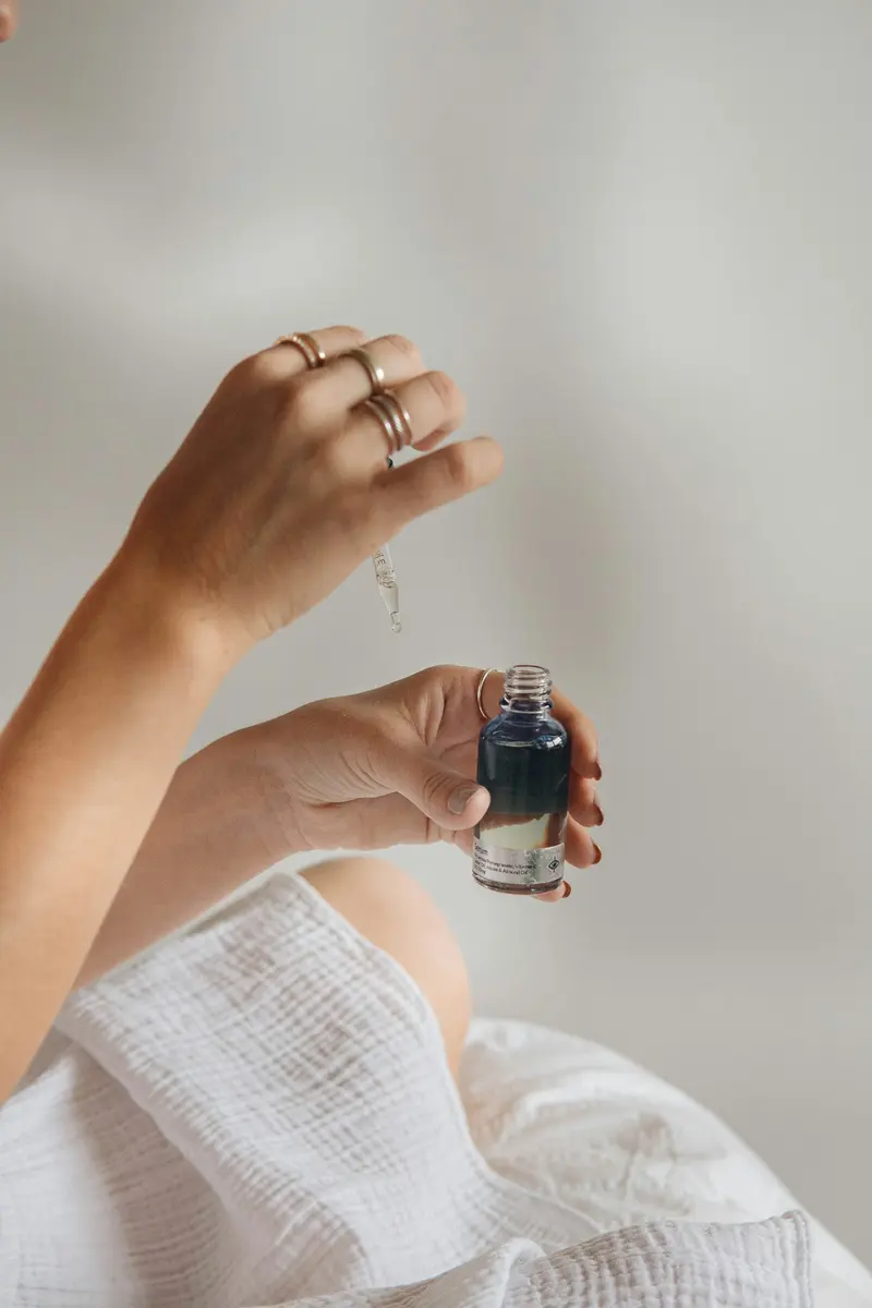 Hand holding a small glass bottle in soft light