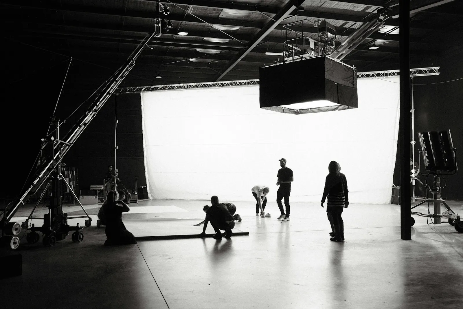 Black and white film studio with a large soft box hung over the set