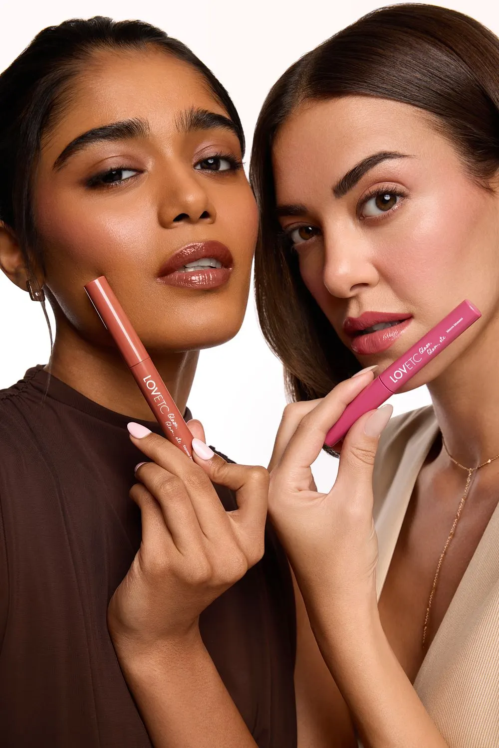 Two models holding brown and pink lip conditioners beside their faces, skin texture visible