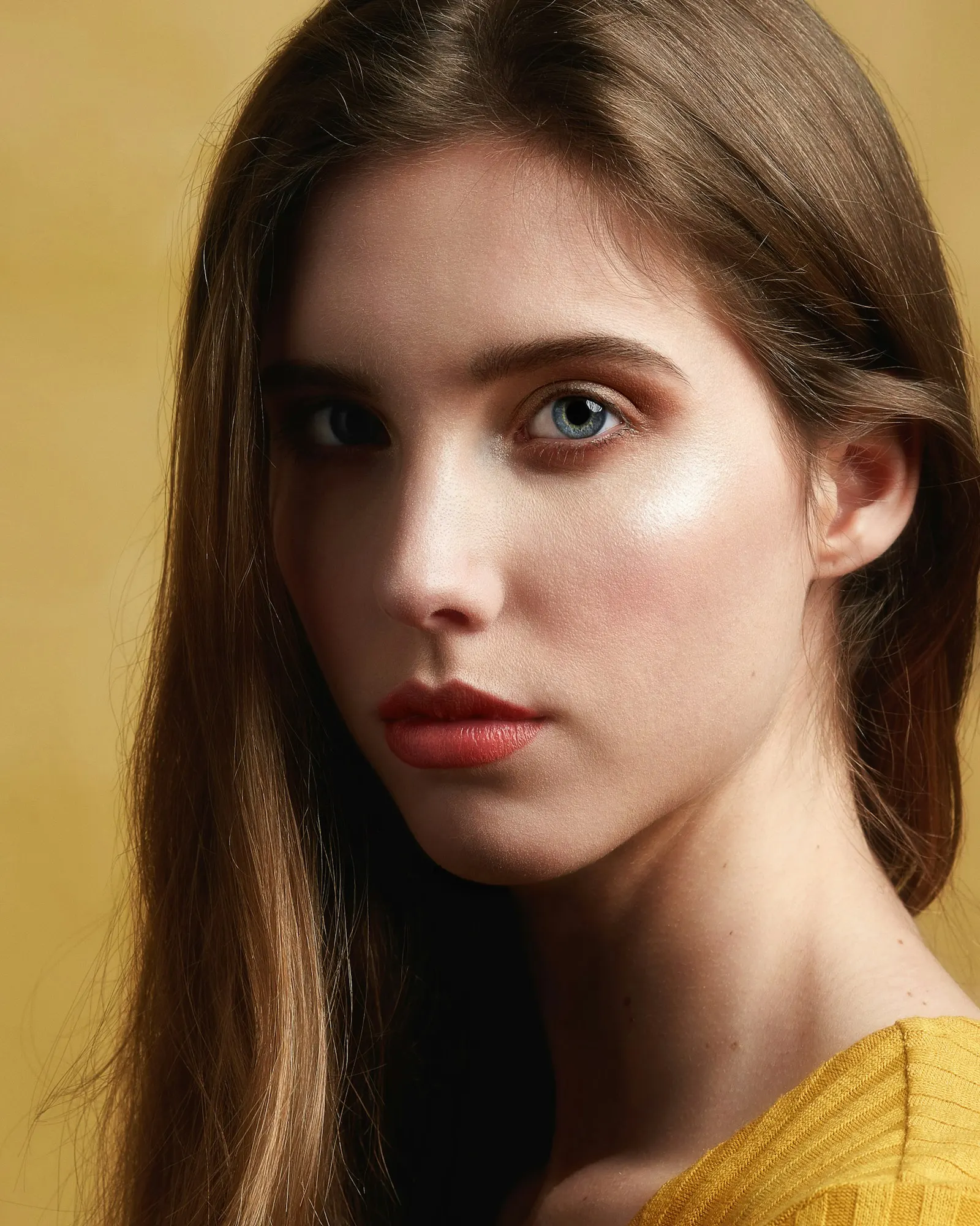 Portrait with natural skin texture against a warm yellow background