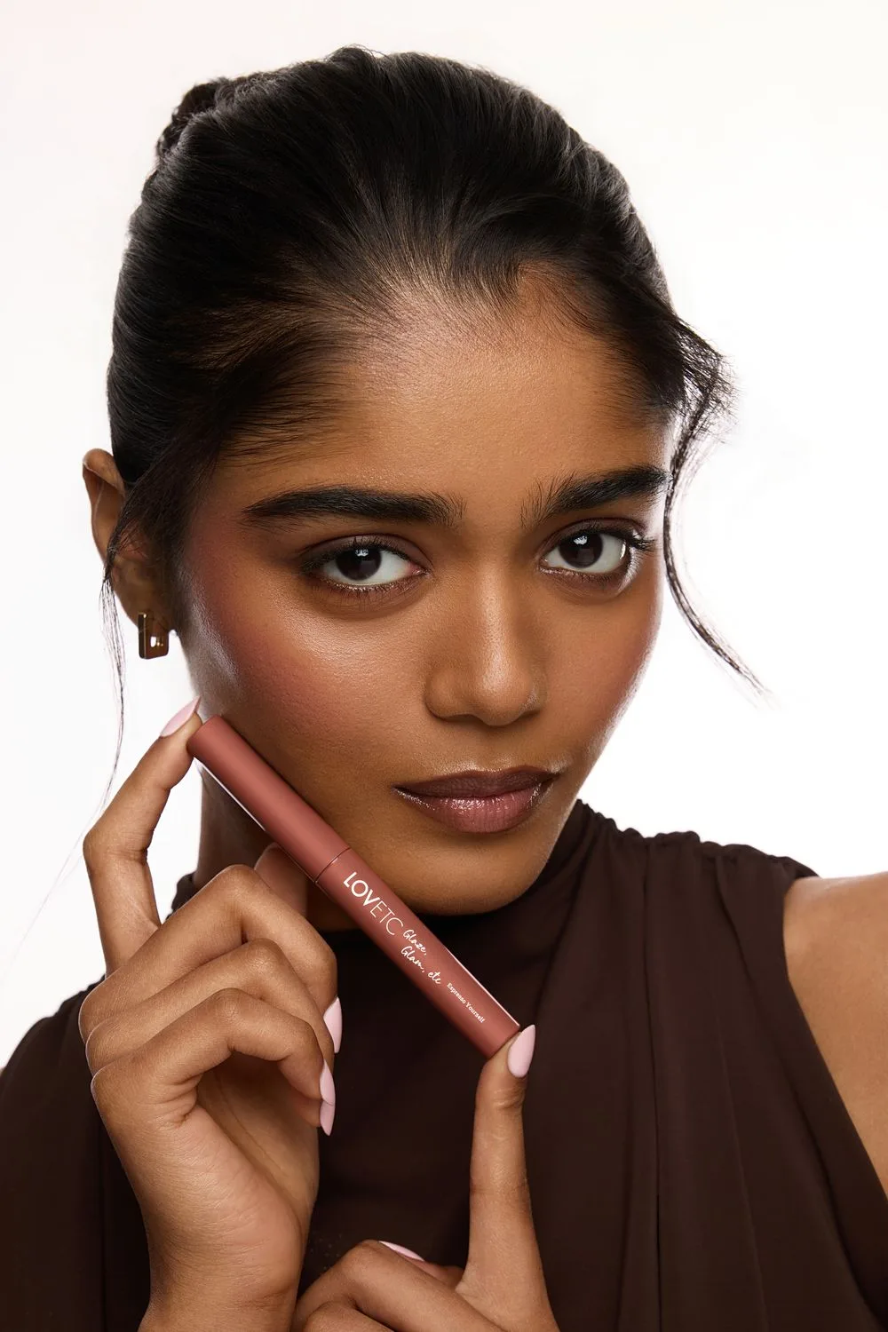 Beauty portrait with the LOVETC lip conditioner held to camera